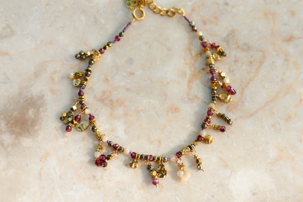 fijn armbandje van bordeaux en fuchsia mineralen met goudkleurige accenten