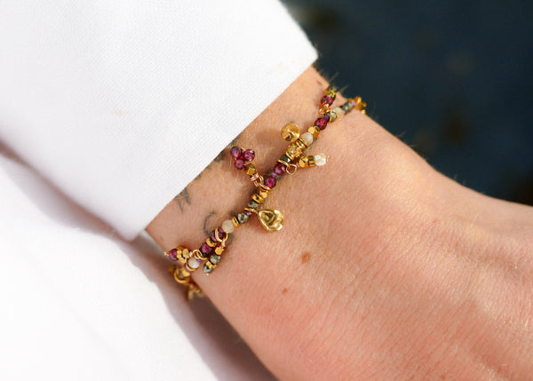 fijn armbandje van bordeaux en fuchsia mineralen met goudkleurige accenten