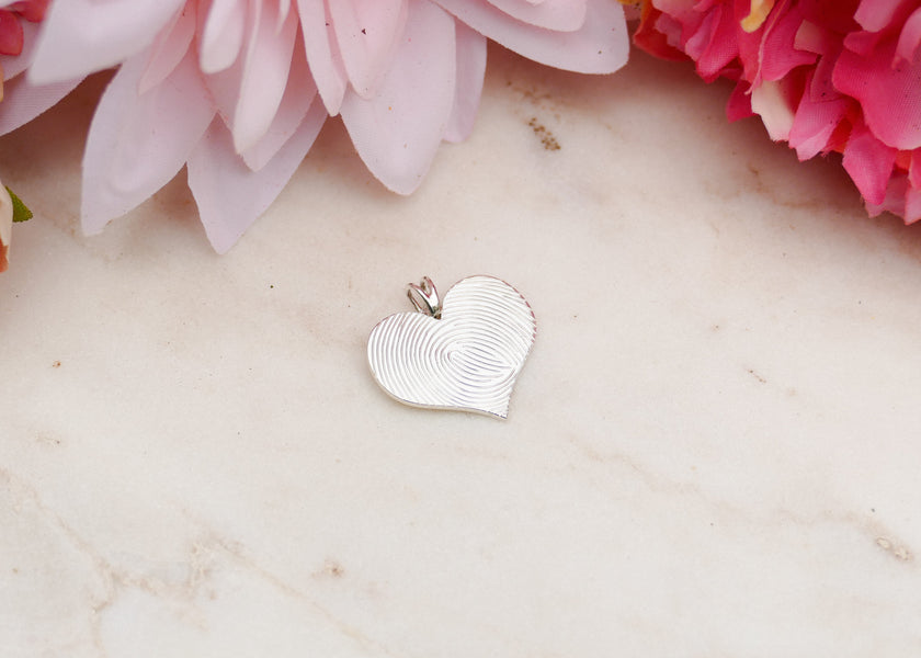 Een hartvormig graveerplaatje met haar opa’s vingerafdruk