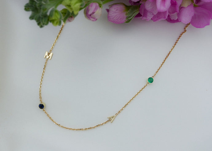 letter collier met de geboortestenen van haar twee kinderen