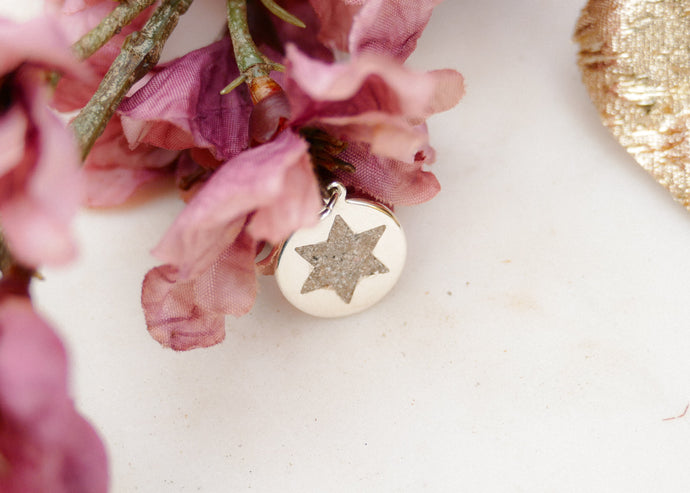 Het as van haar vader in een zilveren hanger voor haar