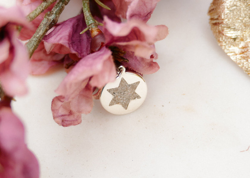 Het as van haar vader in een zilveren hanger voor haar