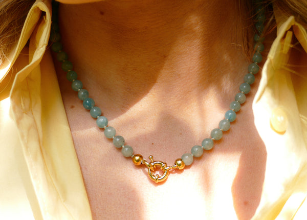 licht blauw mineralen collier met goudkleurig slot