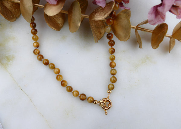hand geknoopt collier van gele tijgeroog mineralen met goudkleurig stainless steel slot