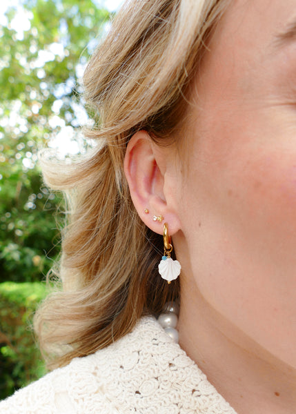 goudkleurige oorringen met witte schelp hangertjes