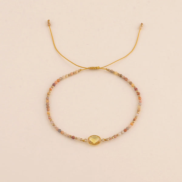 fijn oker geel mineralen armbandje met goudkleurige accenten