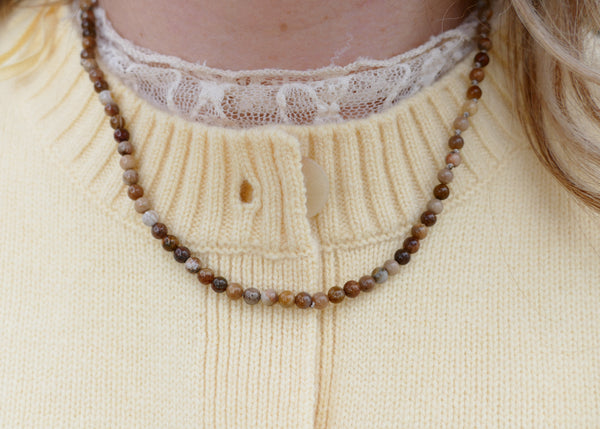 hand geknoopt collier van beige jaspis met goudkleurig groot slot