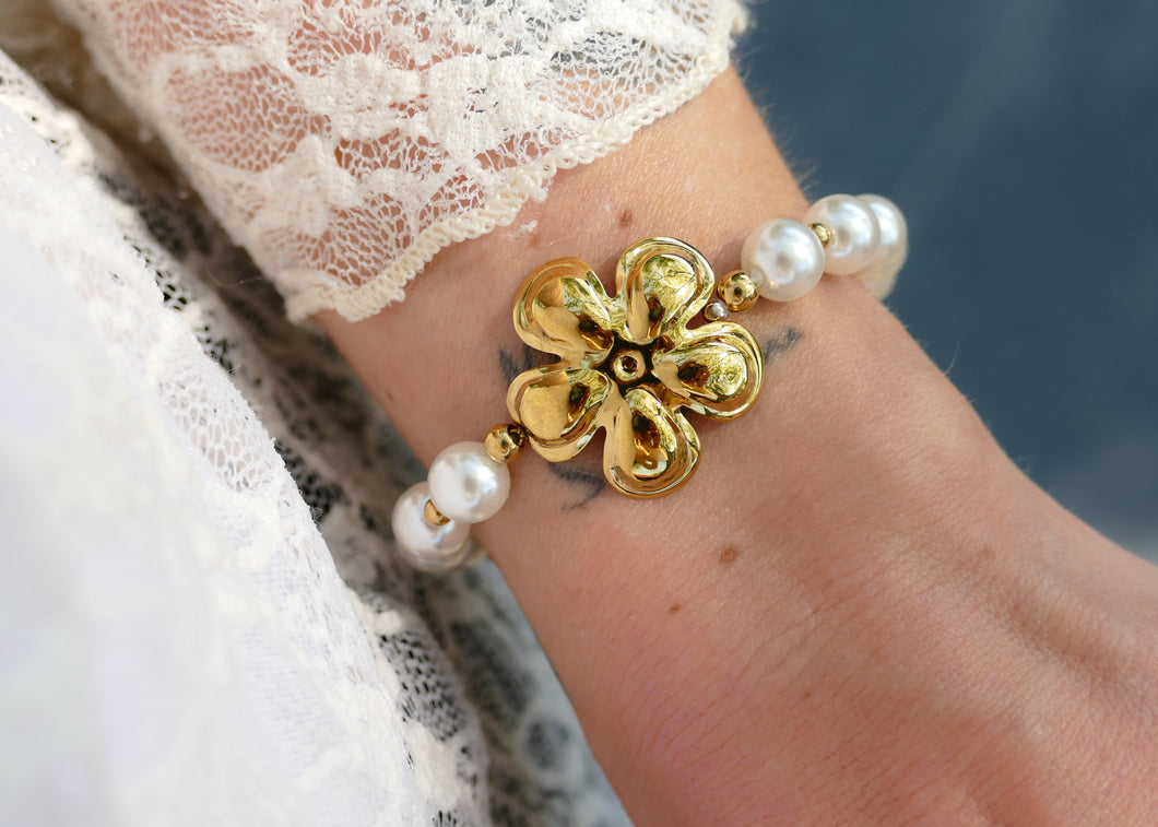 witte parels en grote goudkleurige stainless steel bloem