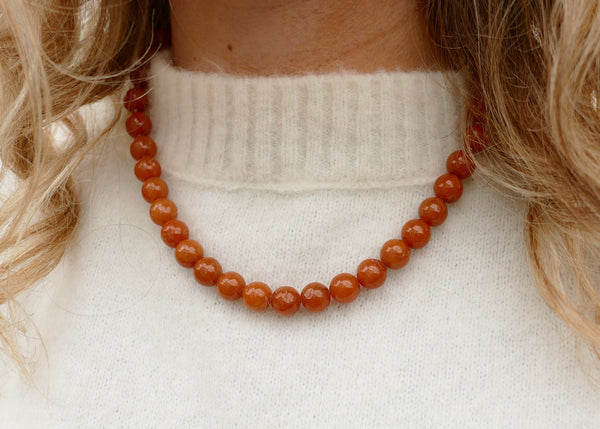 handgeknoopt collier van oranje aventurijn mineralen met goudkleurig groot slot